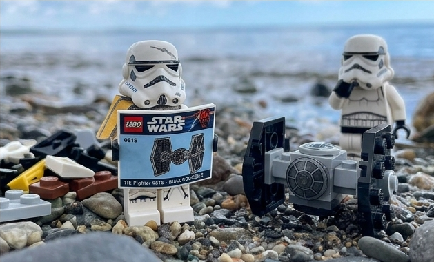 The same LEGO stormtrooper reads the manual the right way round, with the finished build beside him.